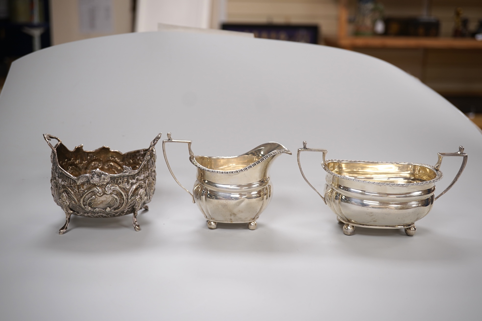 A George V silver two handled sugar bowl and matching cream jug, Z Barraclough & Sons, London, 1918, together with a late 19th century German Hanau silver sugar bowl, 10.5oz.